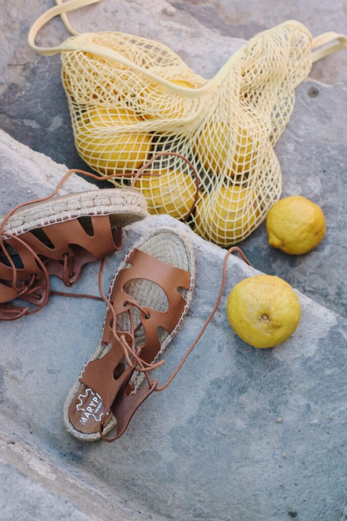 yellow lemon beside brown leather sandals